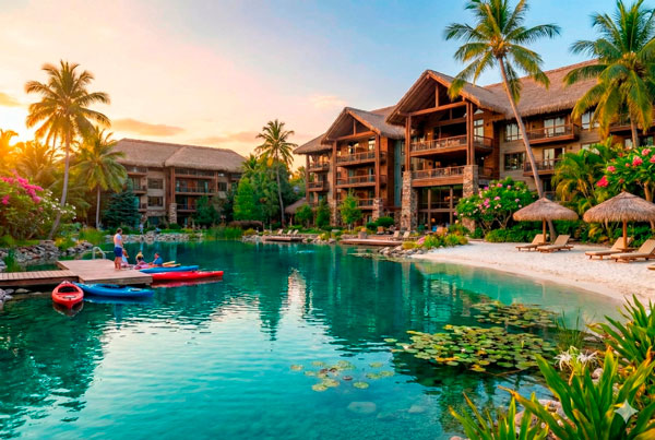 Hotel boutique de lujo con laguna natural cristalina y huéspedes disfrutando